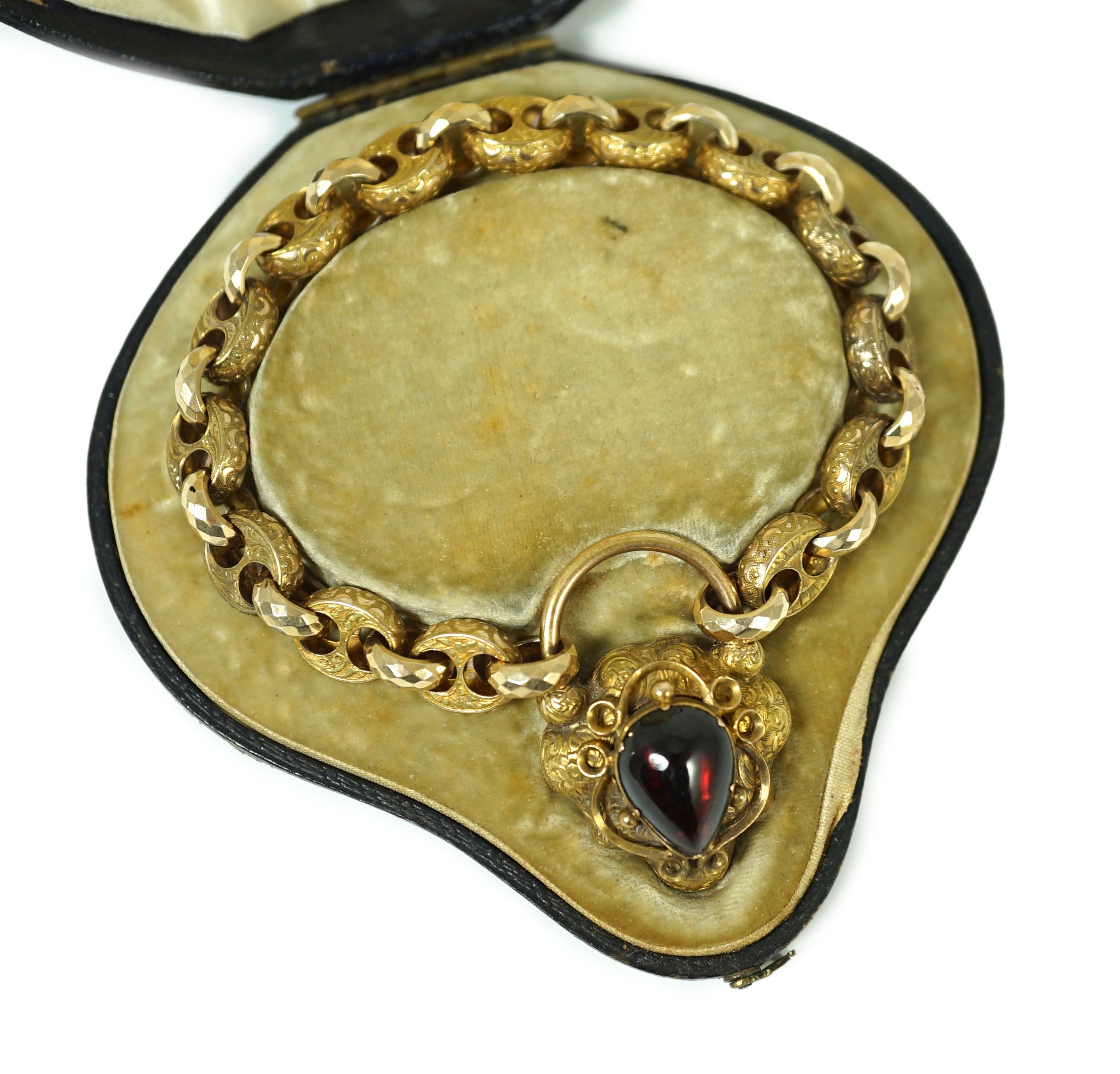 A Victorian engraved and facetted link gold mourning bracelet, with pear shaped foil backed? garnet set heart shape padlock